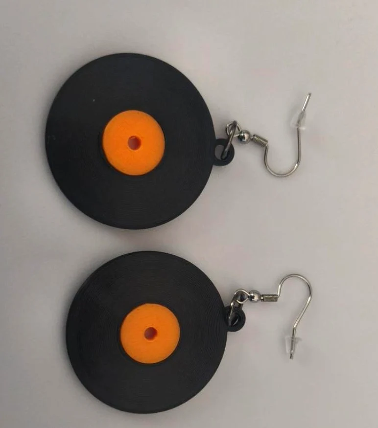 Pair of black record earrings with orange removable center labels